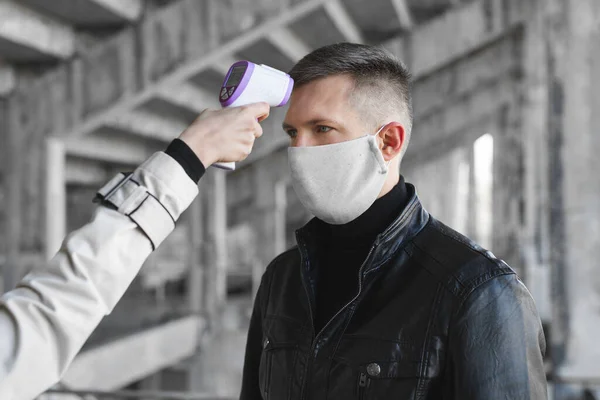 Coronavirus COVID-19 'un taranması ve korunması için dijital termometre ziyaretçisinin ateşini kontrol edin.