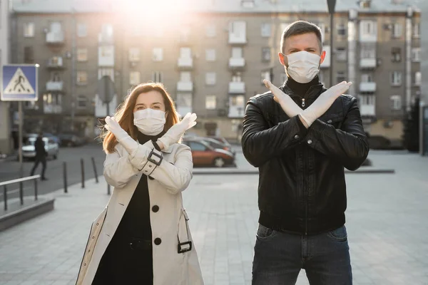 Un uomo e una donna mascherati mostrano un segnale di stop per il coronavirus. La pandemia del 2020. Ferma il coronavirus. Coperta19. Quarantena. Vaccino al coronavirus — Foto Stock