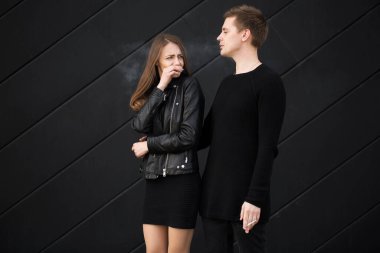 Pasif sigara konsepti. Kadın yüzünü sigara dumanından koruyor. Sigara içmeyen kadın erkeğinden sigarayı bırakmasını ister.