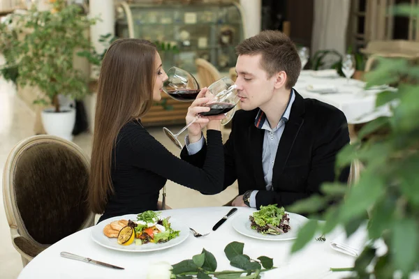 Молодая счастливая влюбленная пара празднует с красным вином в ресторане. Братство . — стоковое фото