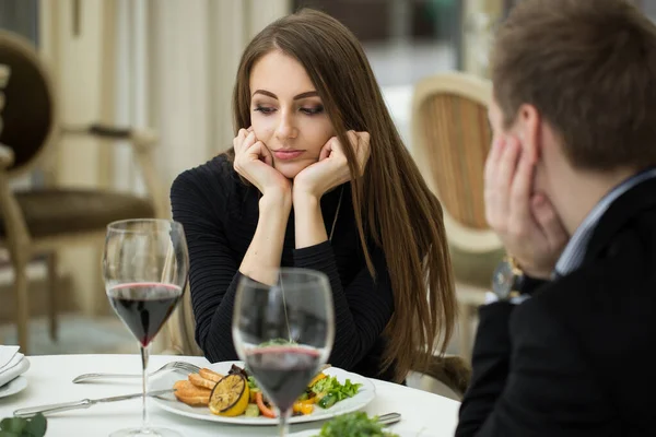 Молодая женщина делает раздражительный жест на плохом свидании в ресторане . — стоковое фото