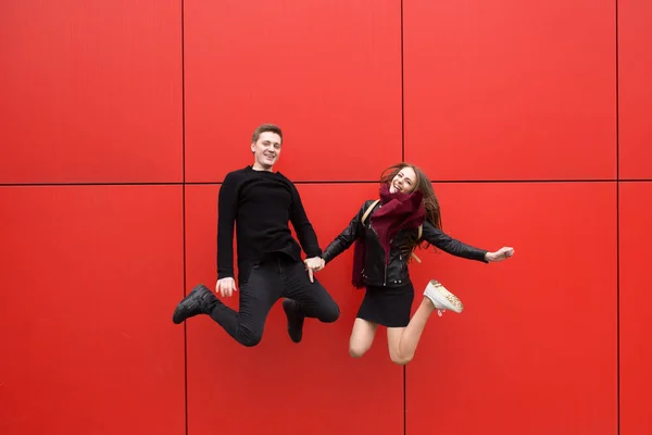 Прыгай. Мужчина и женщина на красном фоне . — стоковое фото