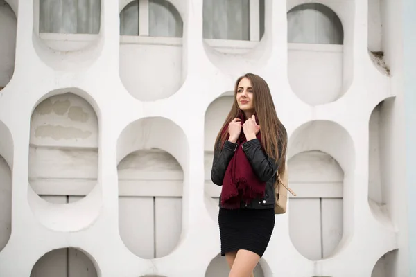 Fashion jonge vrouw in een zwarte rots op een witte muur achtergrond — Stockfoto