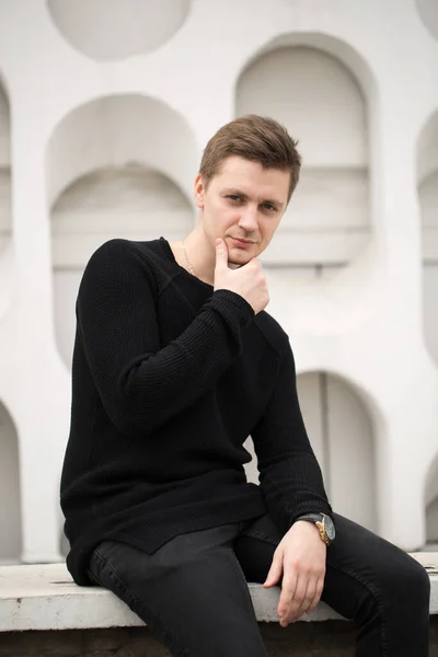 Moda giovane uomo in abiti neri su sfondo bianco parete — Foto Stock