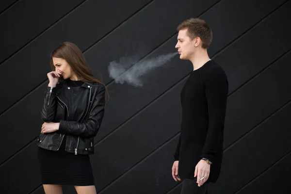 Passive smoking concept. Woman is covering her face from cigarette smoke