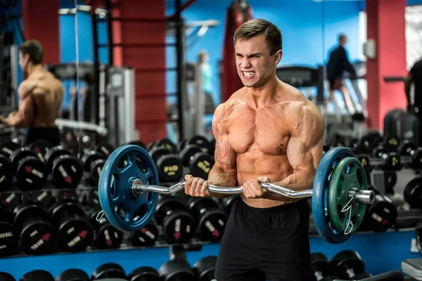 Very power athletic guy standing workout in the gym. — Stock Photo, Image