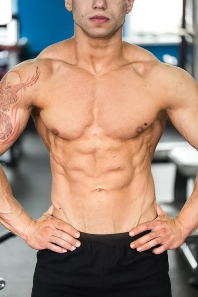 Culturista posando en el gimnasio. Hermosa figura masculina . — Foto de Stock