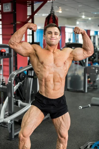 Bodybuilder poseert in de sportschool. Mooie mannelijke figuur. — Stockfoto