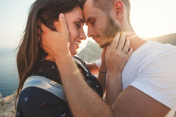 Gli amanti ragazzo e ragazza abbraccio e bacio primo piano sullo sfondo della montagna — Foto Stock