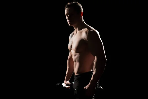 Musculoso y en forma joven culturista fitness modelo masculino posando sobre fondo negro. — Foto de Stock