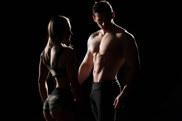 Homem e mulher do desporto. Silhuetas em um fundo preto . — Fotografia de Stock