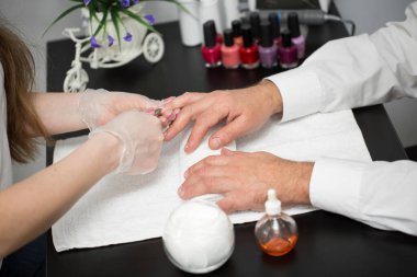 Bir manikürcünün tırnaklarını keserken yakın plan fotoğrafı..