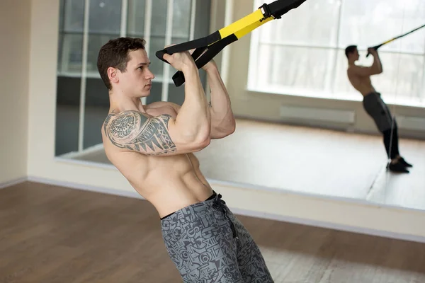 Junger Mann trainiert Liegestütze mit Trageschlaufen im Fitnessstudio Concept Sport Workout gesunder Lebensstil. — Stockfoto
