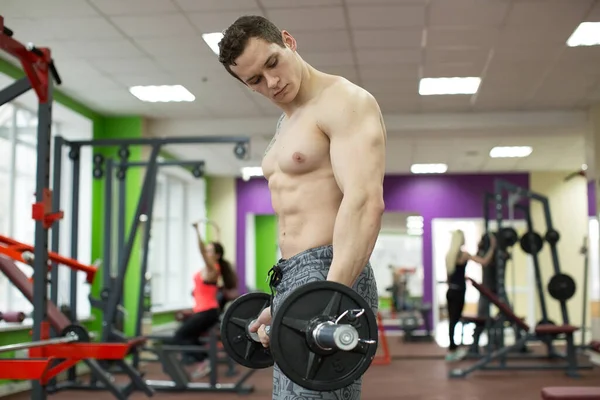 肌肉发达的男人在体育馆里用杠铃做运动，强壮的男性赤身裸体. — 图库照片