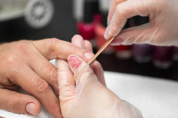 Manikiurzystka robi manicure dla mężczyzny w salonie piękności. — Zdjęcie stockowe