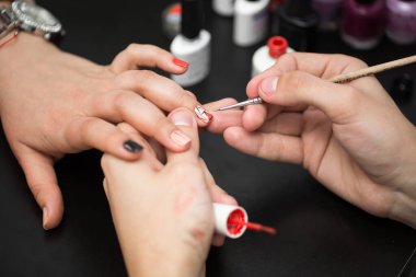 Yakından çekilen adam güzellik salonunda kadına manikür yapıyor..