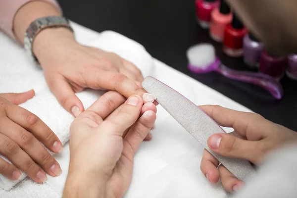 Mężczyzna manikiurzysta robi manicure dla kobiet w salonie piękności — Zdjęcie stockowe