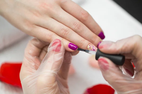 Manicure nail paint pink color. Beauty salon