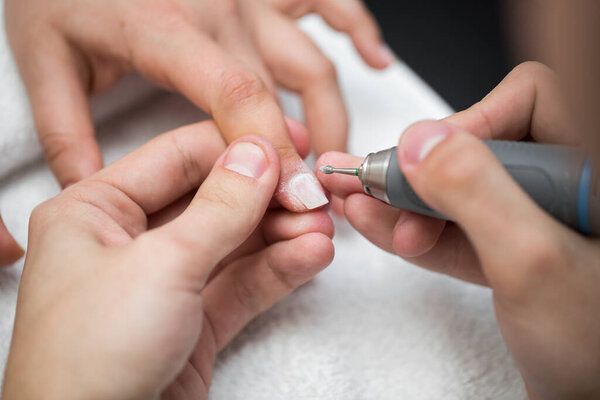 Manicure. The device removes the cuticle. Concept of body care