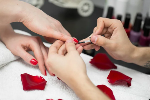 Манікюра. Одяг красивої жінки тримає полірування нігтів з червоними нігтями в польському салоні краси. Зблизька красуня малює самиць-клієнток-нігтів. Концепція краси. Висока резолюція. — стокове фото