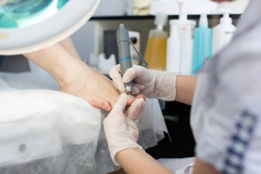 Pedikür makinesiyle pediatri prosedürü. Ayaklarına dikkat et..