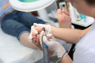 Güzellik salonunda pedikür SPA prosedürü. Ayak pedikürü ameliyatı. Pedikür için elektrikli aygıt.