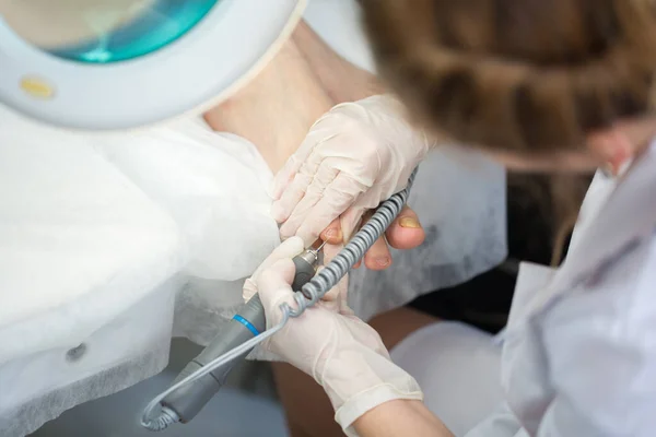 Podiatry procedure with pedicure machine. Care of the feet.