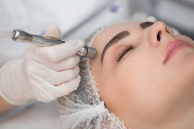 Elmas mikro dermabrüksiyon, kozmetik soyma. Güzellik salonunda mikro cilt bakımı sırasında bir kadın..
