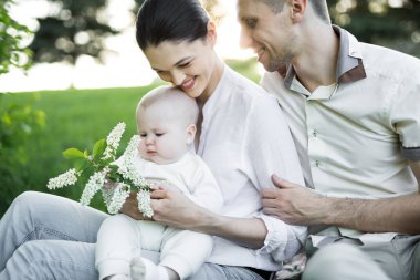 Portre Güzel Anne, Baba ve Bebek açık havada. Mutlu bir aile yaz çayırında.