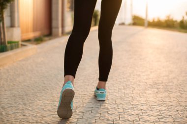 Atletizm koşucusu ayakları ayakkabıyla yolda koşuyor. Kadın Fitness Sunrise Jog Spor Sağlık Konsepti