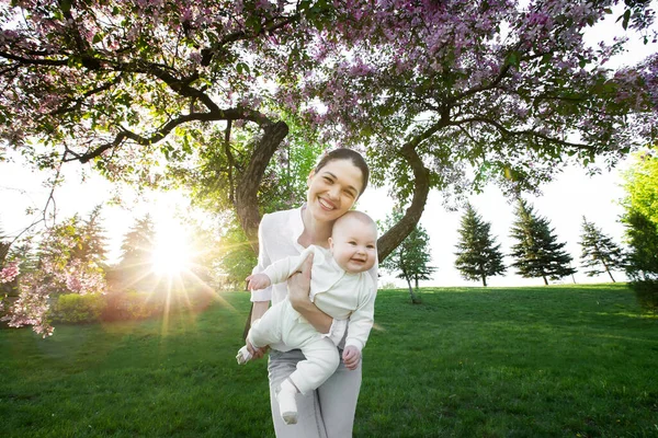 Hermosa madre y bebé al aire libre. Naturaleza. Belleza mamá y su hijo jugando en el parque . — Foto de Stock