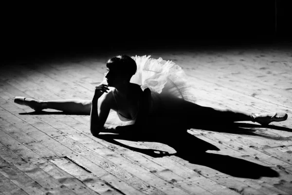 Uma bela bailarina jovem em um tutu posa no palco . — Fotografia de Stock