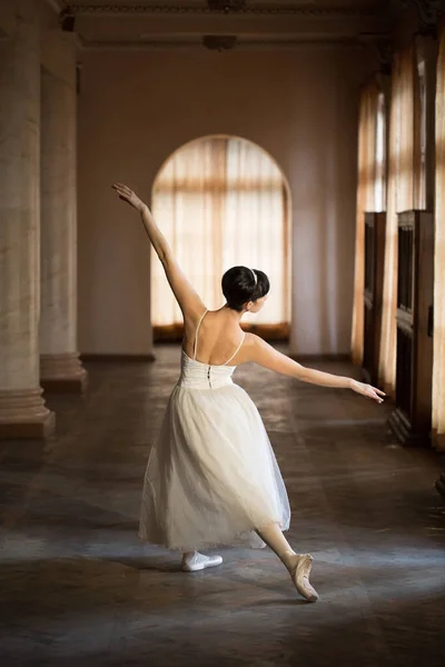 Ballerina in een witte jurk in de balzaal. — Stockfoto