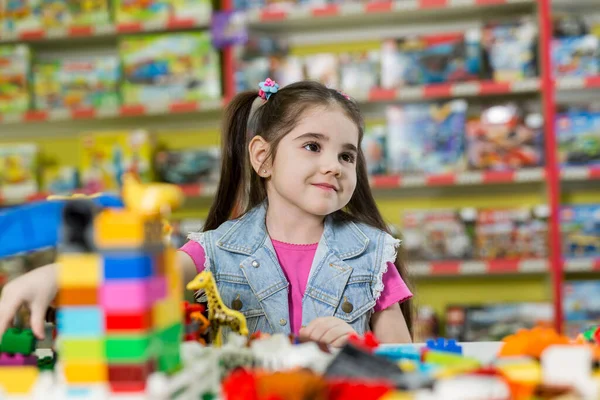 En liten flicka leker med byggstenar i en spelklubb.. — Stockfoto