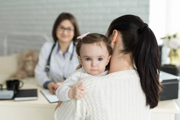 Doktor randevusundaki anne ve çocuğun portresi. Anne ve çocukla hastanede çocuk doktoru toplantısı.
