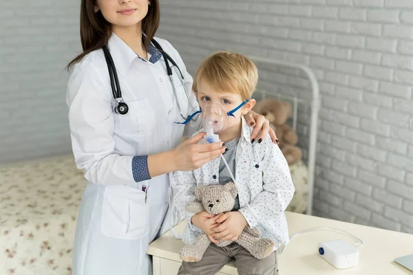 Врач применяет лечение ингаляцией на маленьком мальчике с помощью маски ингалятора для ингаляции астмы — стоковое фото