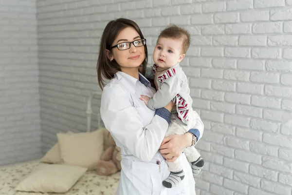 Arzt hält ein Baby an den Händen. — Stockfoto