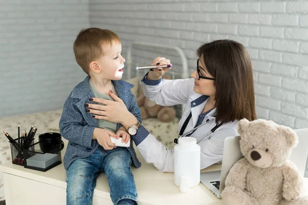 Ärzte untersuchen die Kehle der Kinder. Junge in Kinderarztpraxis — Stockfoto