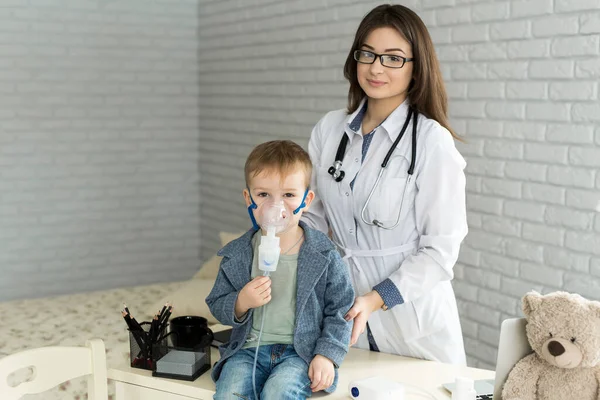Orvos alkalmazó gyógyszer inhalációs kezelés egy kisfiú asztma inhalációs terápia álarccal inhalátor — Stock Fotó