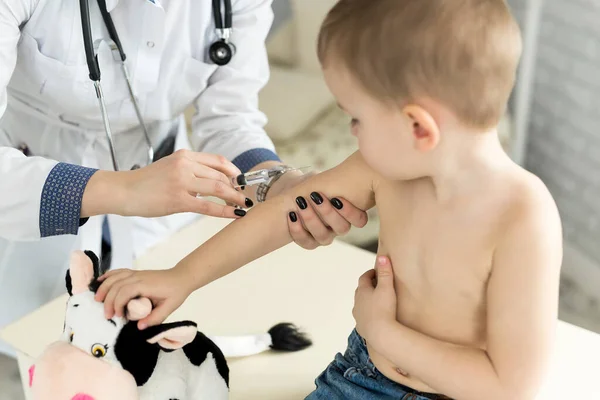 Врач-педиатр делает ребенку внутримышечную инъекцию в руку . — стоковое фото