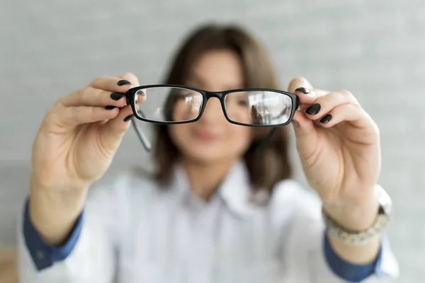 Close up female hands holding eyeglasses. Ophthalmology concept. — Stock Photo, Image