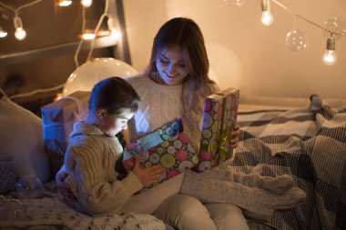 Güzel anne ve kız evin içinde sihirli bir Noel hediyesi açıyorlar. Yeni Yıl