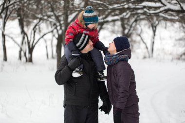 Aile kışın karla kaplı ormanda yürür..