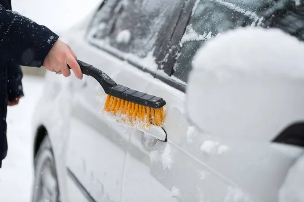Mulher limpando neve do carro no inverno. Punho do carro . — Fotografia de Stock
