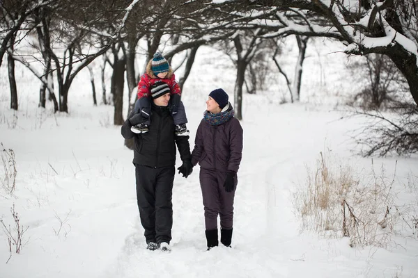 Caminhada em família pela floresta coberta de neve no inverno . — Fotografia de Stock