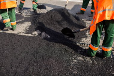Road Street tamirat sırasında kaldırım makinesinde çalışan işçiler. Sokak yeniden ortaya çıkıyor. Taze asfalt yapısı. Kötü yol..