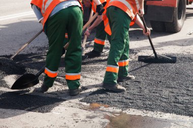 Road Street tamirat sırasında kaldırım makinesinde çalışan işçiler. Sokak yeniden ortaya çıkıyor. Taze asfalt yapısı. Kötü yol..