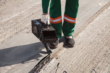 Yol tamiri için asfalt döken adam..