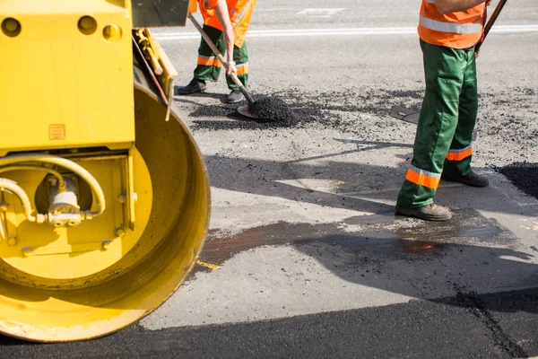 Workers on Asphalting paver machine during Road street repairing works. Street resurfacing. Fresh asphalt construction. Bad road. — Stock Photo, Image