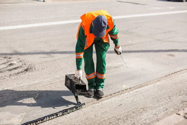The man working asphalt pouring tar for road repair. — Stock Photo, Image